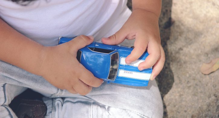 Barnhänder som håller i en leksaksbil